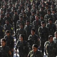 Fighters from the Syrian Democratic Forces (SDF) participate in a military parade during the funeral of a fellow fighter, killed in an offensive by the Islamic State (IS) group against an SDF position, in the Kurdish-controlled city of Qamishly in northeastern Syria, on Sunday. The Kurdish-led force SDF, joint Arab-Kurdish units backed by the US-led anti-jihadist coalition, said it was resuming its offensive against the Islamic State (IS) group in eastern Syria. | AFP-JIJI