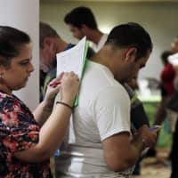 Loredana Gonzalez, of Doral, Florida., fills out a job application at a JobNewsUSA job fair in Miami Lakes in January. | AP