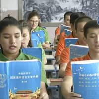 Young Muslims read from official Chinese-language textbooks in classrooms at the Hotan Vocational Education and Training Center in Hotan, in northwest China\'s Xinjiang region, in this file image from undated video footage. | AP