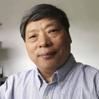 Lu Guang poses for a photo in New York in July. | XU XIAOLI / VIA AP