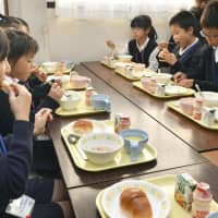 Children eat breakfast Wednesday morning at Ajinadaihigashi Elementary School in Hatsukaichi, Hiroshima Prefecture. | KYODO