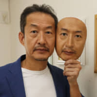 Osamu Kitagawa, head of Real-f Co., shows a superrealistic face mask of his own face in Otsu, Shiga Prefecture. | CHUNICHI SHIMBUN