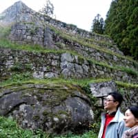 A couple visit the Iwamura Castle ruins in Ena, Gifu Prefecture, that are recently attracting tourists amid growing popularity of stone castle walls. | CHUNICHI SHIMBUN