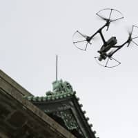 A drone takes aerial photographs of the Aichi Prefectural Government building for inspection purposes in July. | KYODO