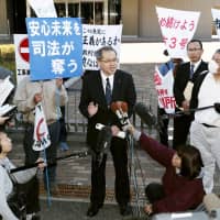 A Shikoku Electric Power Co. official speaks to reporters outside the Takamatsu High Court on Thursday after a ruling was handed down. | KYODO