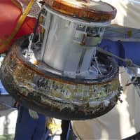 A capsule containing samples from the International Space Station is recovered after it splashes down into the Pacific Ocean near Minamitorishima Island, Japan\'s easternmost territory, on Sunday. | JAXA / VIA KYODO