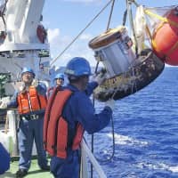 A capsule containing samples from the International Space Station is recovered Sunday after splashing down into the Pacific Ocean near Minamitorishima Island, Japan\'s easternmost territory. | JAXA / VIA KYODO