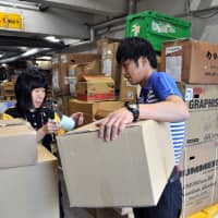 Keisuke Kawabe delivers a parcel to a store in Tokyo\'s Roppongi district last week. | ANDREW MCKIRDY