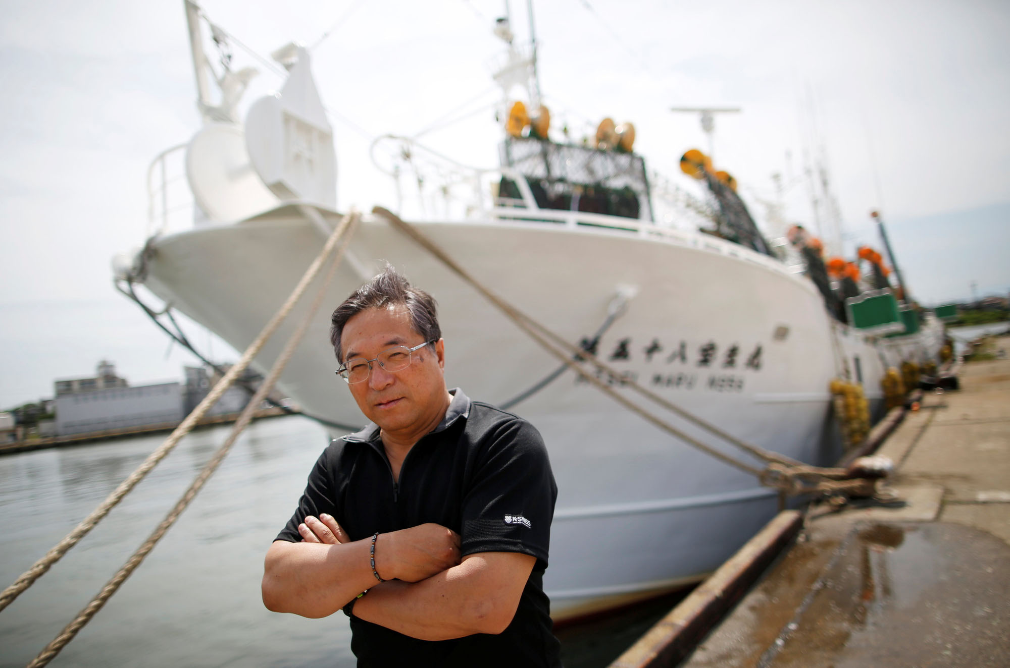 Shigeru Saito, captain of the squid fishing ship Hoseimaru No.58, poses in front of his boat at a port in Sakata, Yamagata Prefecture, on June 5.