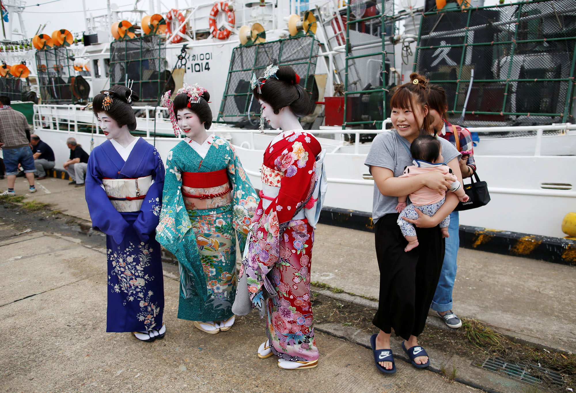Entertainers wearing kimono attend a ceremony celebrating the departure of the squid fishing ships at a port in Sakata, Yamagata Prefecture, on June 6.