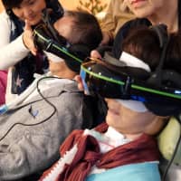 Tour participants with ALS experience inaccessible landmarks using virtual reality headsets on Oct. 14. | CHISATO TANAKA