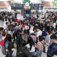 Foreign tourists gather at New Chitose Airport in Sapporo in September. | KYODO