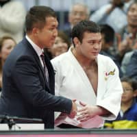 Judoka Aaron Wolf (right) shakes hands with coach Keiji Suzuki after winning the 100-km title at Grand Slam Osaka on Sunday. | KYODO