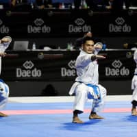 Japan\'s Ryo Kiyuna (left), Takuya Uemura (center) and Arata Kinjo compete in the male team kata final during the 24th Karate World Championships at the WiZink center in Madrid on Sunday. | AFP-JIJI