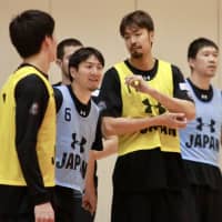 Makoto Hiejima (left) and Kosuke Takeuchi observe the preliminary Japan men\'s national team\'s practice on Wednesday. | KAZ NAGATSUKA