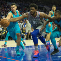 Philadelphia\'s Joel Embiid lunges past Charlotte\'s Willy Hernangomez (41) and Michael Kidd-Gilchrist to save the ball from going out of bounds in overtime at Wells Fargo Center on Friday. | BILL STREICHER / USA TODAY / VIA REUTERS
