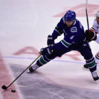 Vancouver\'s Derrick Pouliot controls the puck against Chicago\'s Jonathan Toews in the third period at Rogers Arena on Wednesday. | ?ANNE-MARIE SORVIN / USA TODAY / VIA REUTERS