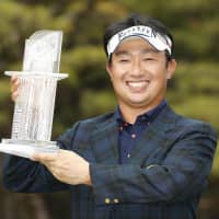 Kodai Ichihara poses with his trophy after carding an 8-under 63 on Sunday to win the Dunlop Phoenix in Miyazaki. | KYODO