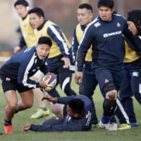 Japan scram half Kaito Shigeno (left) gets in position to pass the ball during the Brave Blossoms\' practice on Thursday in Cheltenham, England. | KYODO