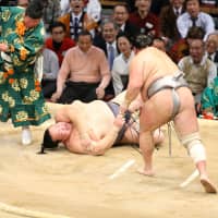 Yokozuna Kisenosato is thrown to the ground by No. 1 maegashira Hokutofuji on Tuesday at the Kyushu Grand Sumo Tournament. NIKKAN SPORTS | KYODO