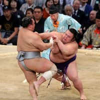 Komusubi Takakeisho (right) forces out No. 1 maegashira Hokutofuji at the Kyushu Grand Sumo Tournament on Tuesday. | NIKKAN SPORTS