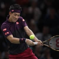 Kei Nishikori hits a shot to Roger Federer in the Paris Masters on Friday. | REUTERS