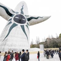 Visitors gather outside the iconic symbol of 1970 World Exposition, the famed Taiyo no To (Tower of the Sun), in Suita, Osaka Prefecture, on March 19, the date its interior was open to the public for the first time in 48 years. Osaka is bidding to host the 2025 Expo, the winner of which will be announced at a general assembly of the Bureau International des Expositions in Paris on Friday. | KYODO