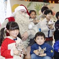 Santa Claus arrives at Narita Airport from Finland on Friday. He is planning to meet children across Japan until he returns to Finland on Dec. 14. | KYODO