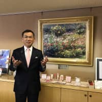 Fukuyama Mayor Naoki Edahiro in front of a painting of roses. | MAIKO MURAOKA