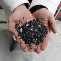 Christofer Costes, a French inventor who created a machine that turns plastic waste into fuel, displays pieces of plastic in Puget-Theniers, France, Dec. 14. | REUTERS