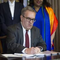 Acting EPA Administrator Andrew Wheeler signs an order withdrawing an Obama era emissions standards policy, at the EPA Headquarters in Washington Thursday. | AP