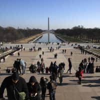 People climb the stairs of the Lincoln Memorial Wednesday as the partial government shutdown continues in Washington. In the background is the Washington Monument. A shutdown affecting parts of the federal government appeared no closer to resolution Wednesday, with President Donald Trump and congressional Democrats locked in a hardening standoff over border wall funding that threatens to carry over into January. | AP