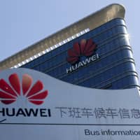 An information board for an employees\' shuttle bus is on display near the Huawei office building at its research and development center in Dongguan in south China\'s Guangdong province Dec. 18. The U.S. dispute with China over a ban on tech giant Huawei is spilling over to Europe, the company\'s biggest foreign market, where some countries are also starting to shun its network systems over data security concerns. | AP