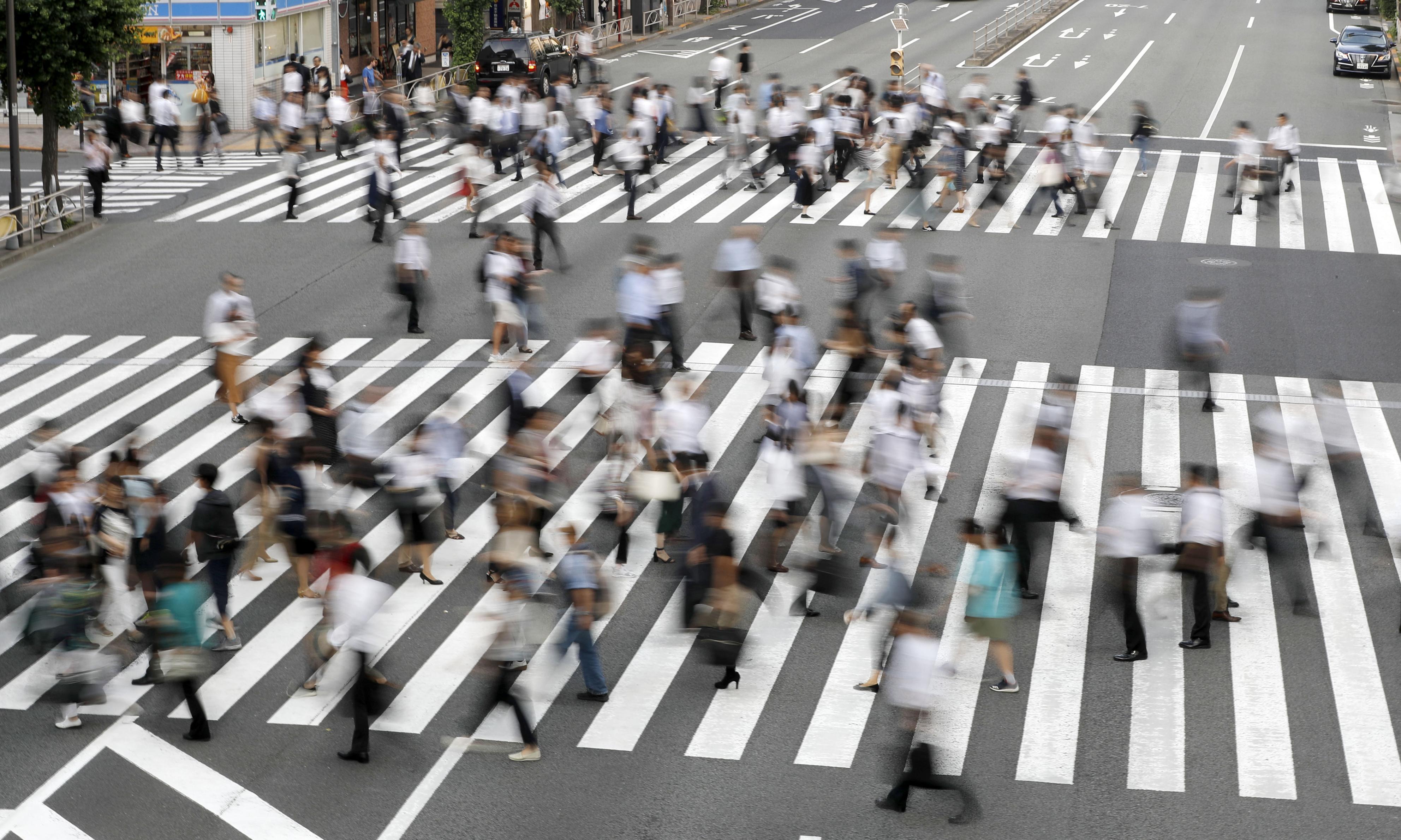 People cross a road near Tamachi Station in Tokyo. The country’s unemployment rate climbed for the second consecutive month in November, government data showed Friday. | KYODO