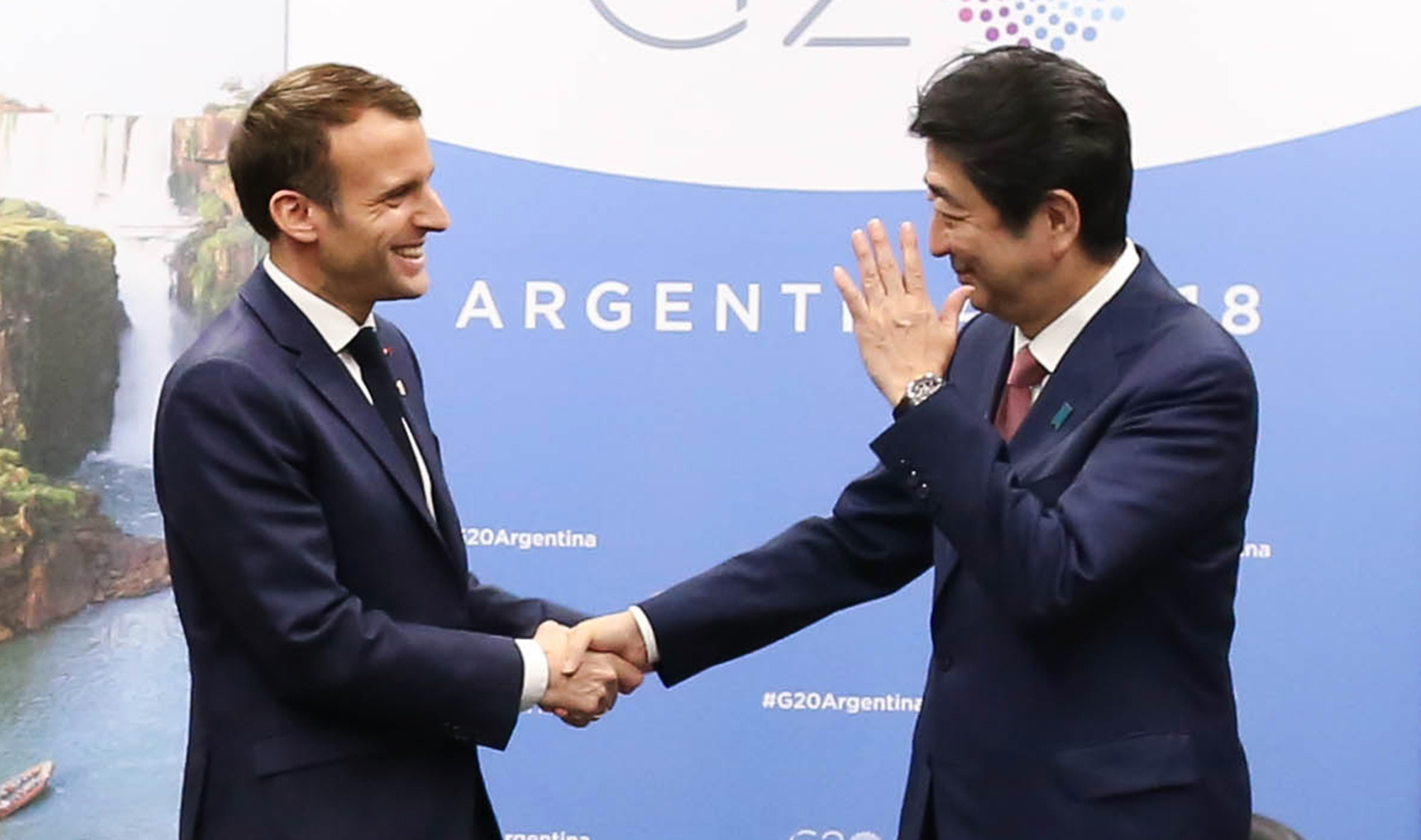 French President Emmanuel Macron shakes hands with Prime Minister Shinzo Abe during a meeting on the sidelines of the Group of 20 summit in Buenos Aires on Friday. | AFP-JIJI