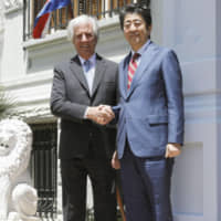 Prime Minister Shinzo Abe is welcomed by Uruguayan President Tabare Vazquez in Montevideo on Sunday. | KYODO