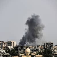 Smoke billows following an airstrike on the western frontline of Raqqa, Syria, during a 2017 offensive by the U.S.-backed Syrian Democratic Forces, a majority Kurdish and Arab alliance, to retake the city from Islamic State (IS) group fighters. The United States military will continue its air campaign in Syria at least in the short term, the Pentagon said Thursday after President Donald Trump declared victory over the Islamic State group. | AFP-JIJI