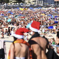 Beachgoers celebrate Christmas Day at Bondi Beach in Sydney. | AAP / VIA AP