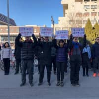 Students hold up signs as they protest against the change in a student-run Marxist group\'s leadership at Peking University in Beijing on Friday. | AFP-JIJI