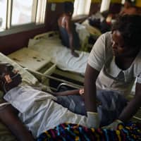 Hawanatu Conteh, a nurse at Connaught Hospital, tends to a patient while the hospital\'s doctors strike over pay and conditions, in Freetown Dec. 4. | REUTERS