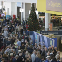 People wait near the departures gate at Gatwick Airport on Thursday. | AP