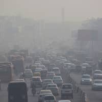 Indian commuters drive amid heavy smog along a busy road past the South Extension area of New Delhi on Thursday. Smog levels spike during winter in Delhi, when air quality often eclipses the World Health Organization\'s safe levels. | AFP-JIJI