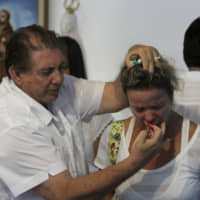 Joao Teixeira de Faria uses scissors to perform a \"spiritual surgery\" on a woman\'s nose in Abadiania, Brazil, on Feb. 23, 2012. | AP