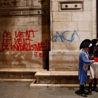 A graffit-vandalized wall is seen Sunday at the Arc de Triomphe a day after clashes with protesters wearing yellow vests, a symbol of a French drivers\' protest against higher diesel taxes, in Paris. | REUTERS