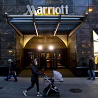 Pedestrians pass a Marriott hotel in Chicago on Nov. 30. | BLOOMBERG