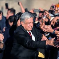 Andres Manuel Lopez Obrador greets supporters during Mexico\'s 58th presidential inauguration event at Mexico City\'s central plaza, the Zocalo, on Saturday. | BLOOMBERG