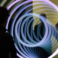 People view a piece titled \"Three Circles,\" by Chul Hyun Ahn, shown by the C. Grimaldis Gallery at the Art Miami show during Miami Art Week last Thursday. | AP