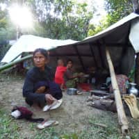 A Myanmar family displaced from the recent fighting between government troops and the ethnic Arakan Army take shelter at a displacement camp housing over 700 people in Kyauktaw township in Rakhine state on Sunday. The western territory is a tinderbox of ethnic and religious divisions and security forces have clashed with both Rohingya insurgents and much better armed Rakhine fighters from the mostly Buddhist Arakan Army. | AFP-JIJI