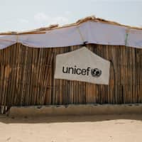 A banner with the UNICEF logo is seen hanging on a makeshift school at an internally displaced persons (IDP) camp on the outskirts of Maiduguri, northeast Nigeria, last year. | REUTERS