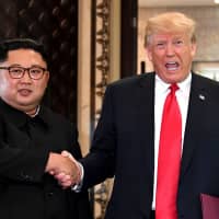 U.S. President Donald Trump and North Korean leader Kim Jong Un shake hands following a signing ceremony during their summit at the Capella Hotel on Singapore\'s Sentosa Island in June. | AFP-JIJI